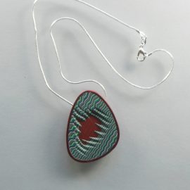 S345 A quirky irregular shaped and designed pendant, mainly in shades of blue green and beige. It is suspended on an 46 cm (18 inches) snake chain.
