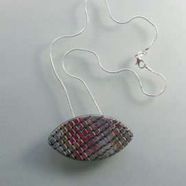 S349 This oval pendant has a random, mainly pink and orange mosaic style pattern. It is suspended on an 46 cm (18 inches) snake chain.